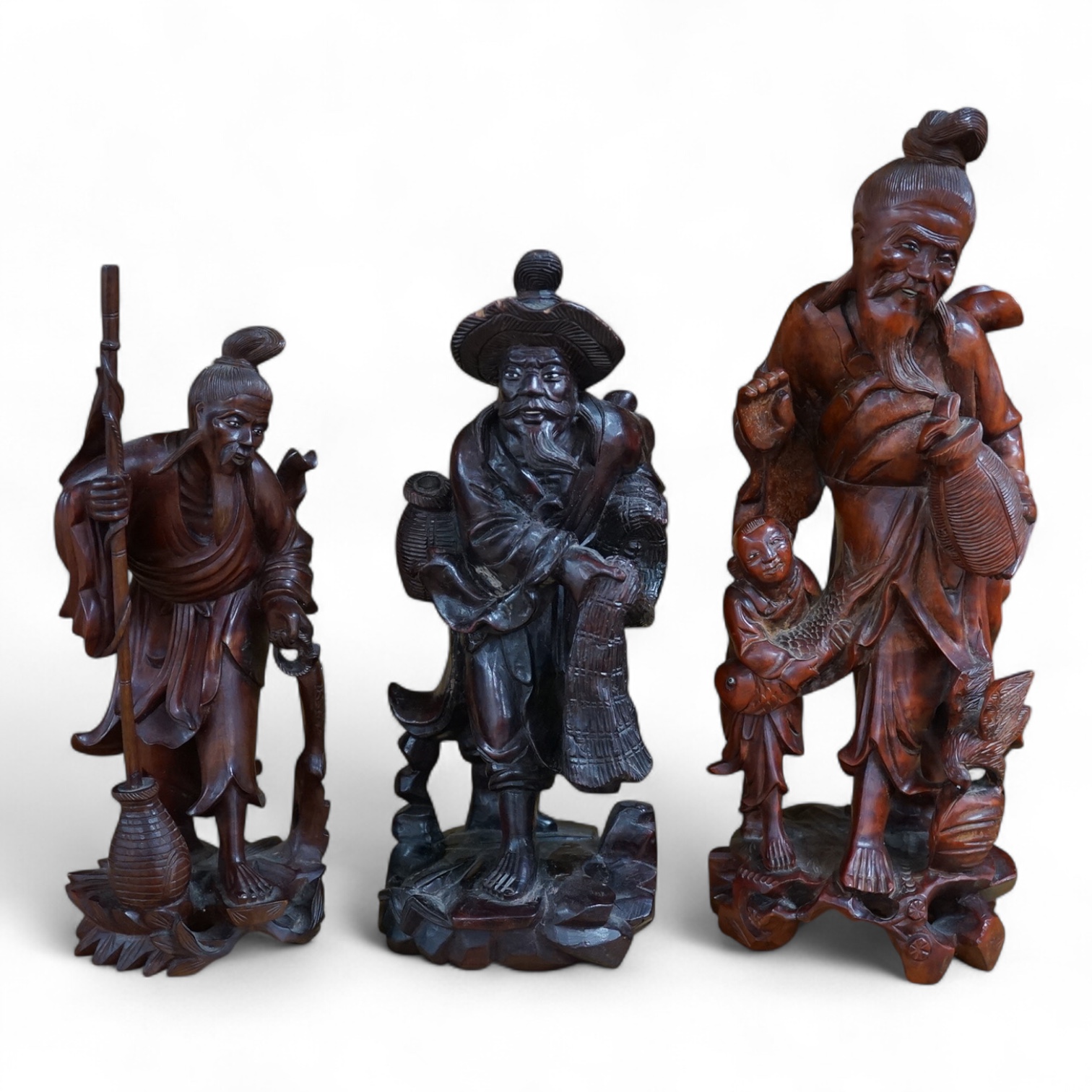 Three Chinese carved wood figures of elders, largest 37cm high